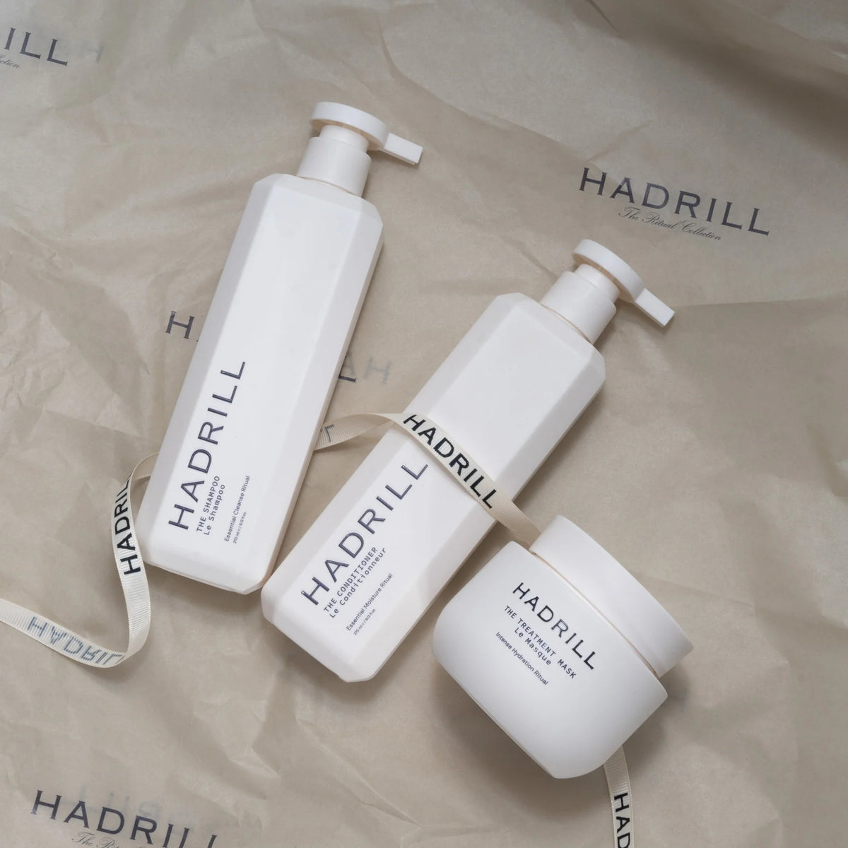 Hadrill Ritual Trio (unboxed) shampoo, conditioner and treatment mask on branded tissue paper with ribbon.